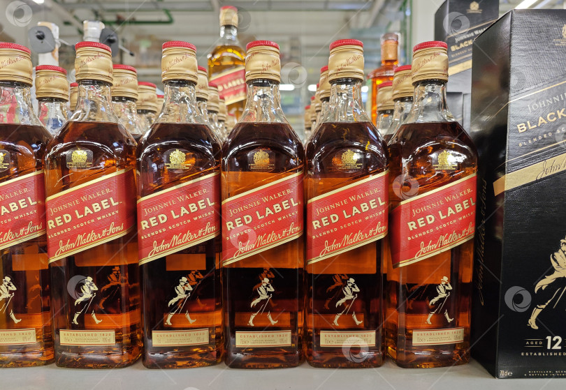 Скачать Бутылки виски Johnnie Walker Scotch Red Label на полке магазина в супермаркете фотосток Ozero