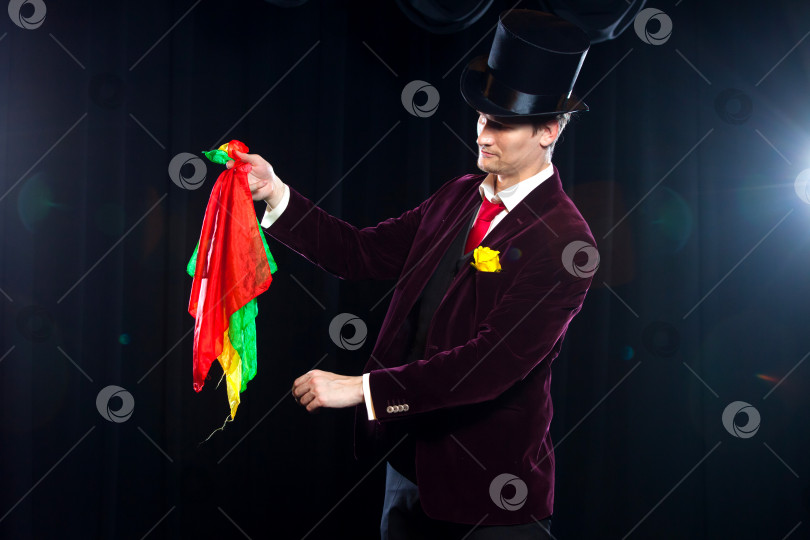 Скачать Magician, Juggler man, Funny person, Black magic, Illusion focus with colored cloth with cloths фотосток Ozero