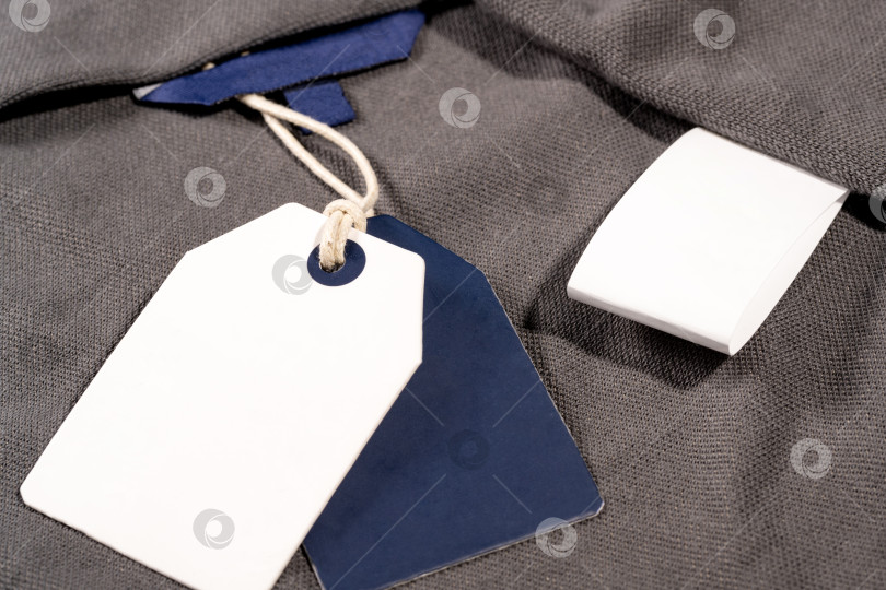 Скачать Снимок крупным планом бело синих бирок для одежды на веревочке с пробелом для копирования и пустой биркой фотосток Ozero