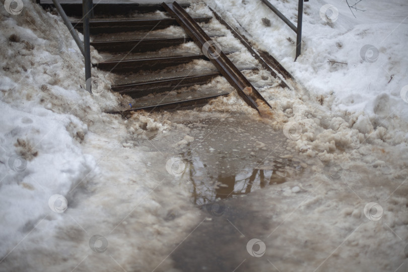 Скачать Ледяная дорожка в городе. Обледенение асфальта. Неудобное место для пешехода. фотосток Ozero