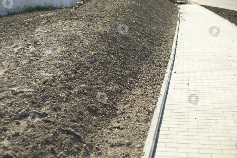 Скачать Почва в парке. Площадка для посадки травы. Выкопанная земля вдоль дорожки. фотосток Ozero