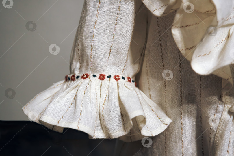 Скачать Рукав белого облегающего платья из льна с вышитыми узорами. Избирательный избирательный фокус фотосток Ozero