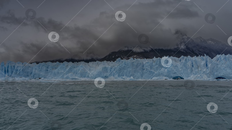 Скачать Стена голубого тающего льда простирается над ледниковым озером. фотосток Ozero