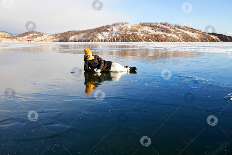 Скачать Счастливая девушка лежит на льду замерзшего озера Байкал. фотосток Ozero