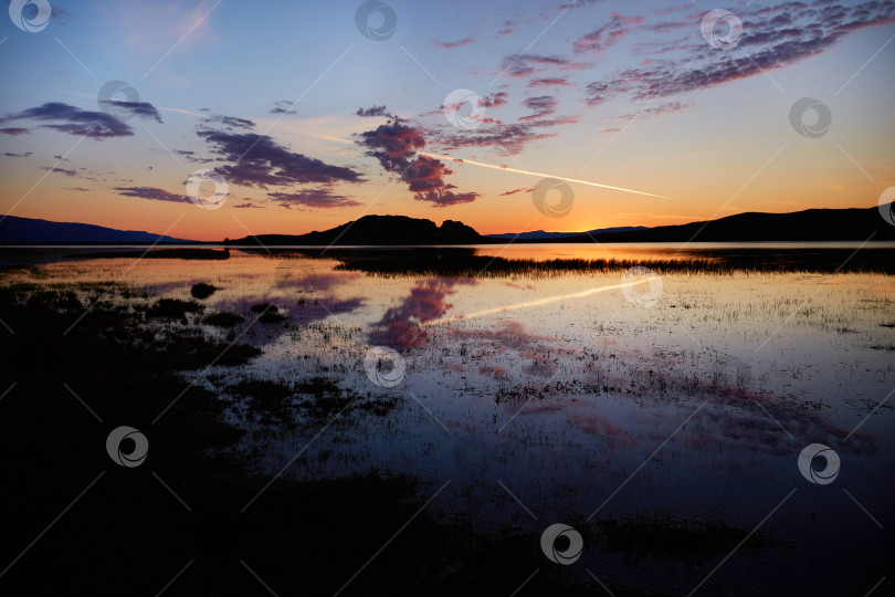 Скачать Красочный восход солнца на озере Байкал. Облака отражаются на поверхности воды. фотосток Ozero