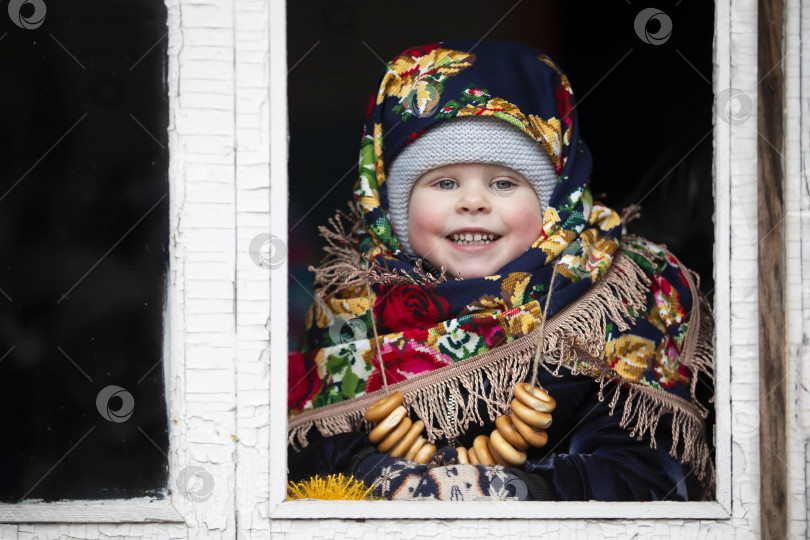 Скачать Маленькая девочка в русском платке с бубликами на празднике Масленица. фотосток Ozero