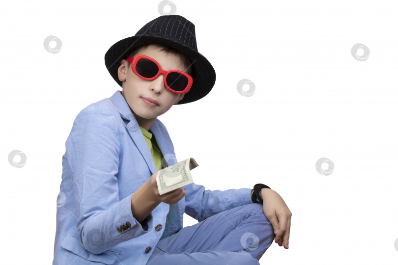 Скачать Симпатичный богатый мальчик в очках держит в руках доллары. Финансовое образование, молодой миллионер, инвестиции, кредиты, выигрыши фотосток Ozero