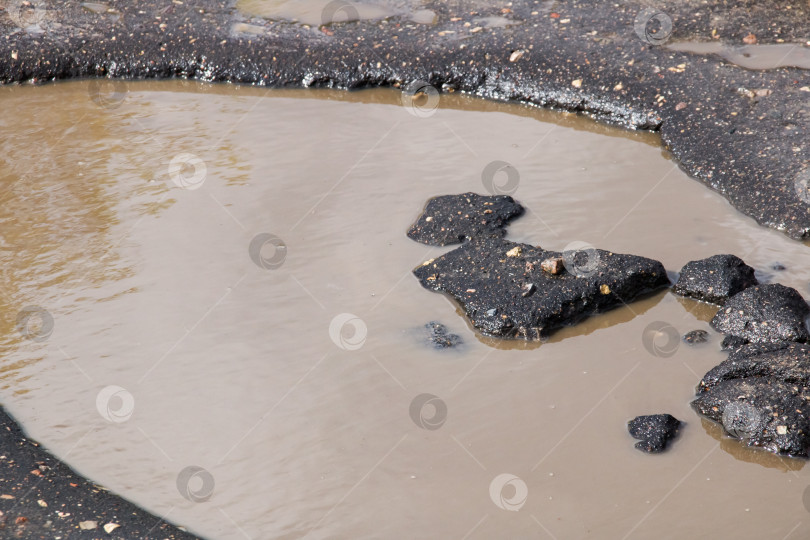 Скачать Яма на тротуаре и лужа грязной воды фотосток Ozero