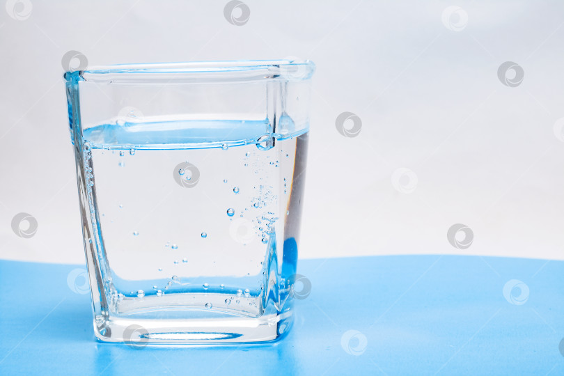 Скачать Стеклянный стакан с водой с пузырьками на белом фоне фотосток Ozero