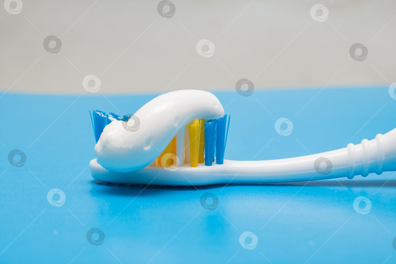 Скачать Зубная щетка и зубная паста на синем фоне фотосток Ozero