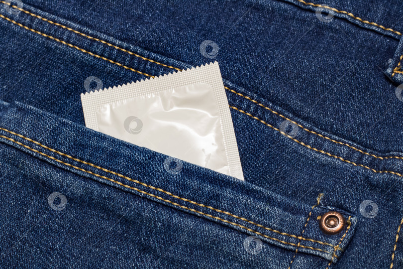 Скачать Презерватив в белой упаковке в кармане джинсов фотосток Ozero