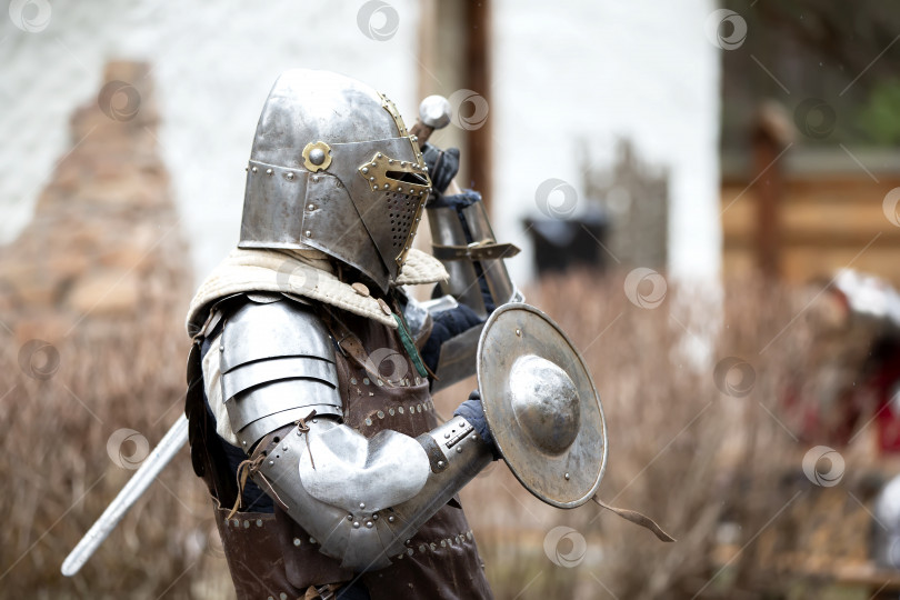 Скачать Старинный средневековый рыцарь в доспехах с защитным металлическим щитом. Железный век. фотосток Ozero