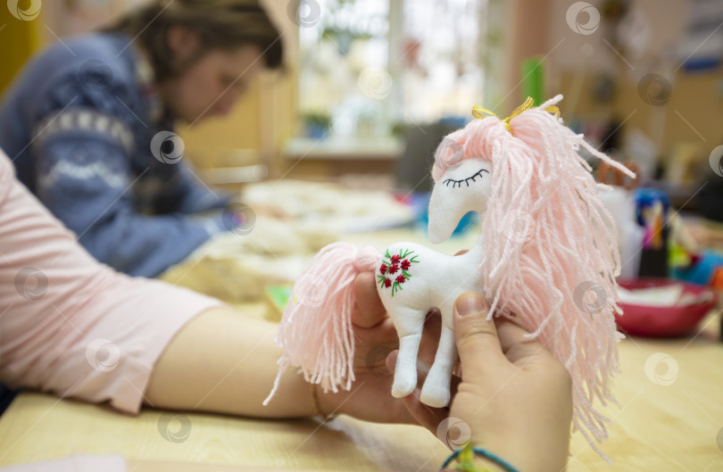 Скачать Игрушечная самодельная розовая лошадка в руках умелца. фотосток Ozero