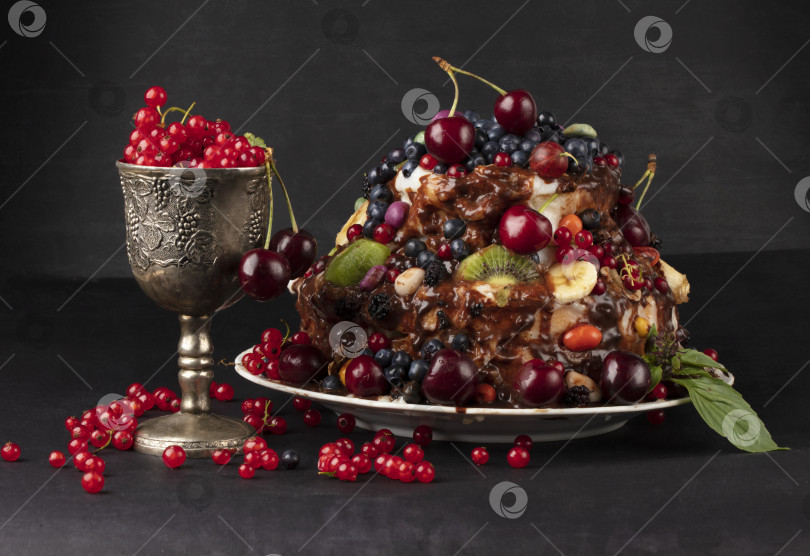 Скачать Роскошный торт с фруктами и ягодами в стеклянном бокале на темном фоне. фотосток Ozero