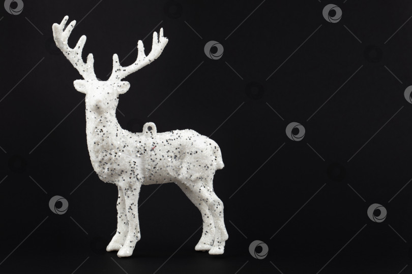 Скачать Праздничный темный рождественский фон. Белый олень на черном фоне. фотосток Ozero