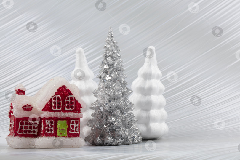 Скачать Рождественский или новогодний фон с серебристой заснеженной елкой и красным игрушечным домиком. Яркий праздничный фон. фотосток Ozero