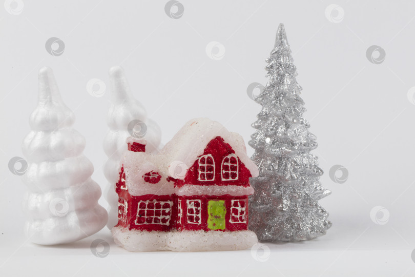 Скачать Рождественская сцена, миниатюрный дачный поселок. Рождественские маленькие красные домики, олени и заснеженные ели на белом фоне. Праздничные современные украшения. фотосток Ozero