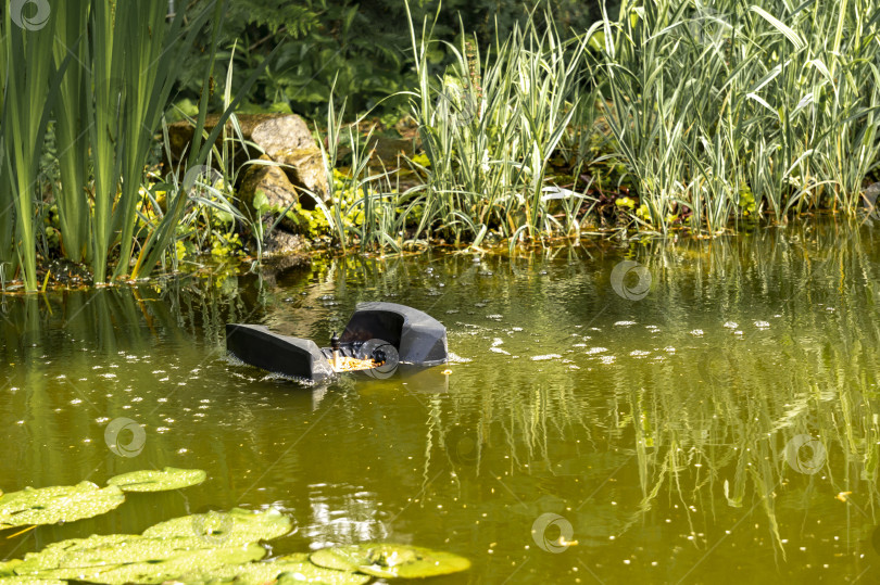 Скачать Скиммер плавает на поверхности воды и собирает листья, грязь с поверхности. фотосток Ozero