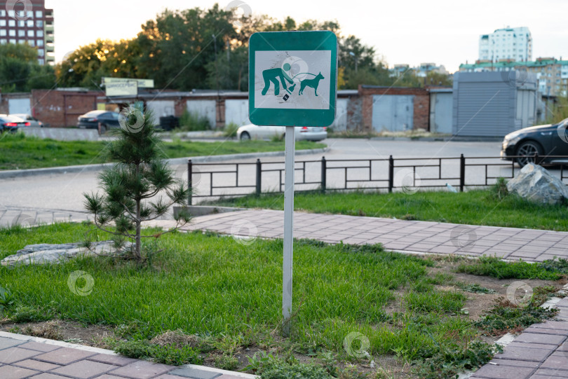Скачать Информационная табличка: - Выгул собак на фоне газона в парке запрещен. Никаких собачьих какашек, фото символа. выгул собак запрещен. Знак "Выгул собак запрещен" установлен на газоне. фотосток Ozero