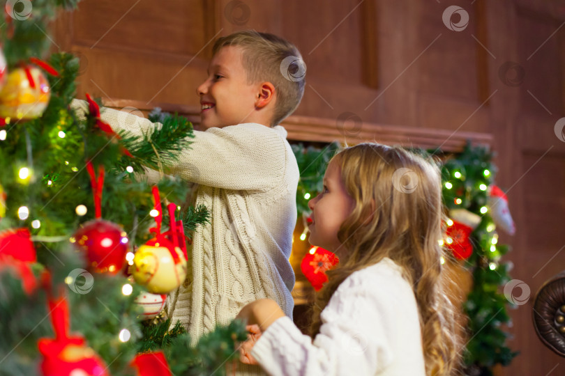 Скачать Портрет счастливых детей, украшающих рождественскую елку.Семья, рождество, зима, счастье и концепция людей. фотосток Ozero