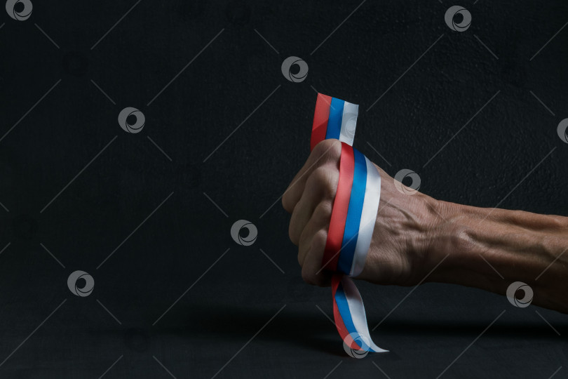 Скачать Мужская рука держит российский флаг фотосток Ozero