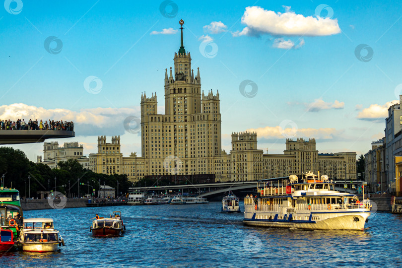 Скачать Большой прогулочный катер плывет по Москве-реке в противоположном направлении к сталинской высотке на Котельнической набережной. фотосток Ozero