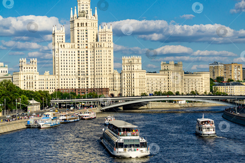 Скачать Ясный солнечный день. По реке плывут прогулочные катера с людьми. Вид на Москву-реку и сталинскую высотку с Котельнической набережной с наплавного моста фотосток Ozero