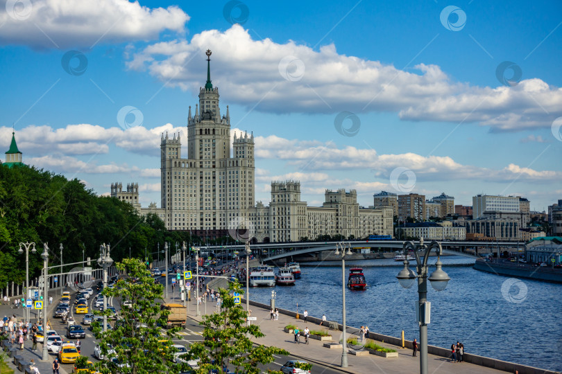 Скачать Движение автомобилей по Москворецкой набережной с высоты наплавного моста в парке Зарядье. На заднем плане мост и небоскреб на Котельнической набережной. фотосток Ozero