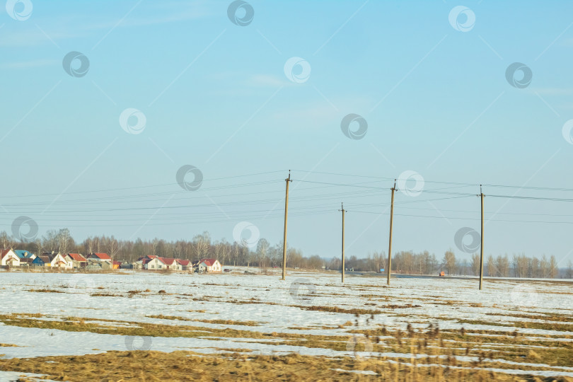 Скачать Зимний солнечный пейзаж, поле, лес и дома фотосток Ozero