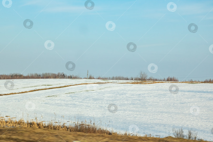 Скачать Зимний солнечный пейзаж, поле, лес и дома фотосток Ozero