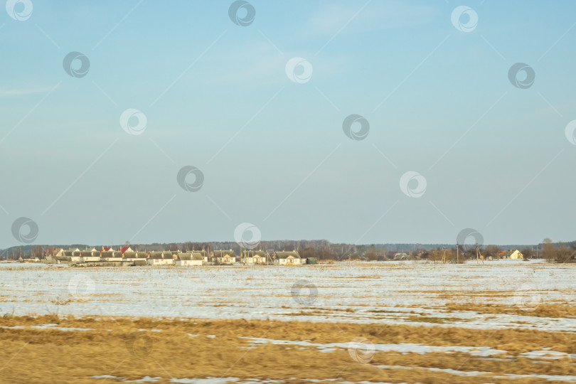 Скачать Зимний солнечный пейзаж, поле, лес и дома фотосток Ozero