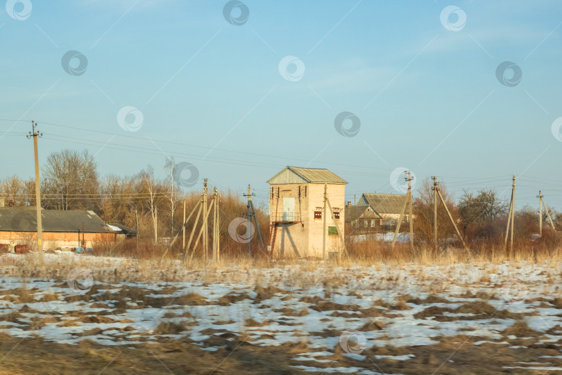 Скачать Зимний солнечный пейзаж, поле, лес и дома фотосток Ozero