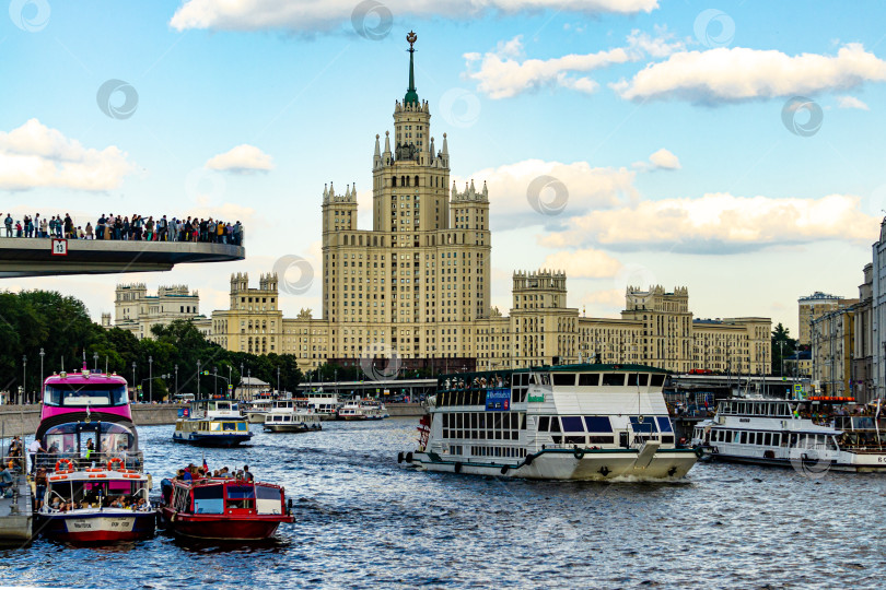 Скачать Прогулочные катера с людьми на борту плывут по Москве-реке. Над рекой плавучий мост. фотосток Ozero