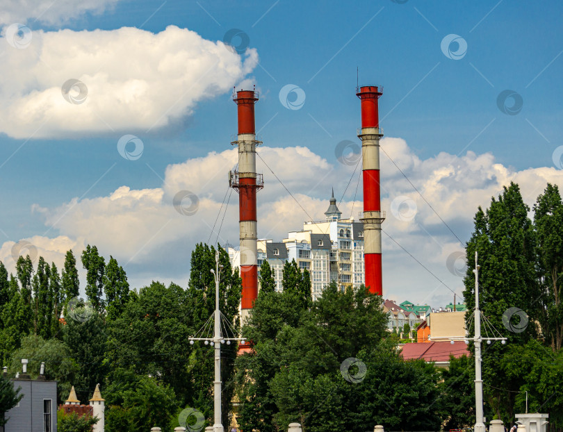 Скачать Две трубы городской теплоэлектростанции, расположенной недалеко от Адмиралтейской площади, на фоне голубого неба с белыми облаками. фотосток Ozero
