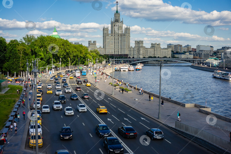 Скачать Движение автомобилей по Москворецкой набережной с высоты наплавного моста в парке Зарядье. На заднем плане - сталинская высотка на Котельнической набережной. фотосток Ozero