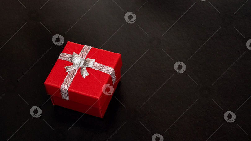 Скачать Красная коробка с подарком на темном фоне фотосток Ozero
