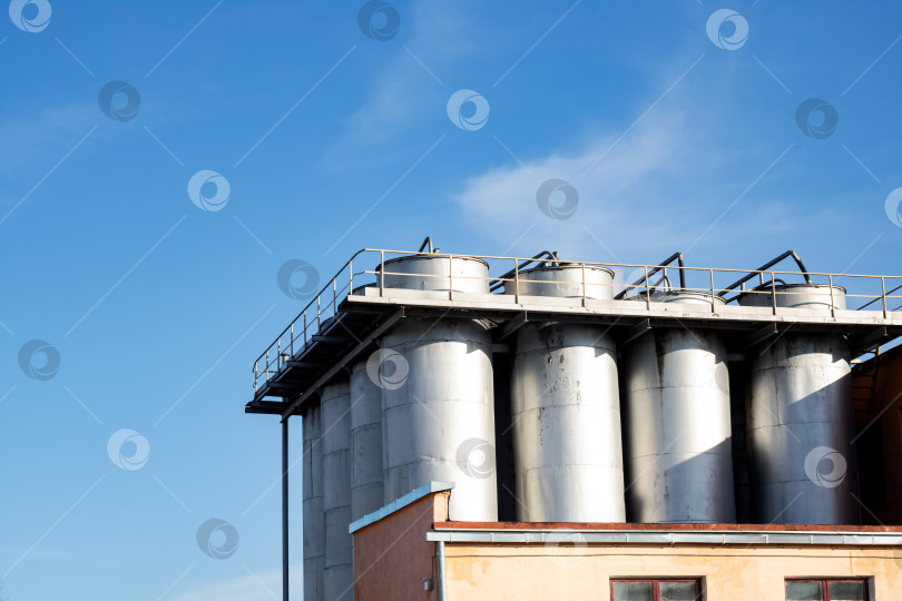 Скачать Большие металлические промышленные контейнеры на фоне голубого неба фотосток Ozero