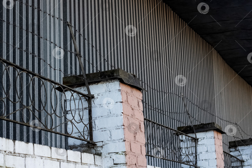 Скачать Колючая проволока на высоком заборе крупным планом фотосток Ozero