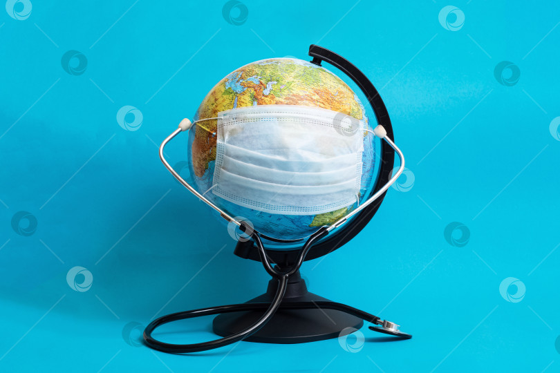 Скачать Глобус в медицинской защитной маске и стетоскоп на синем фоне фотосток Ozero
