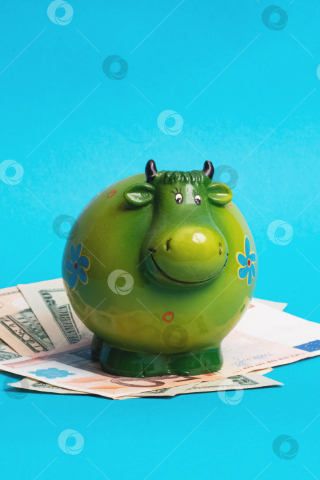 Скачать Коровья копилка для денег корова на разложенных деньгах фотосток Ozero