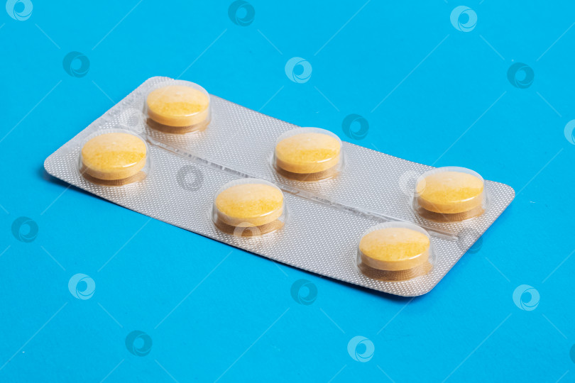 Скачать Желтые таблетки в упаковке на синем фоне фотосток Ozero