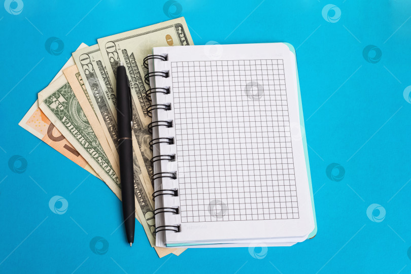 Скачать Блокнот, ручка и деньги на синем фоне фотосток Ozero