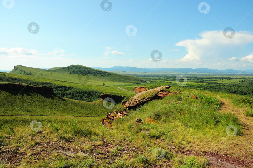 Скачать Вид с вершины скалистого холма на брешь в разрушенной древней стене, идущей вдоль склонов полого холма. фотосток Ozero