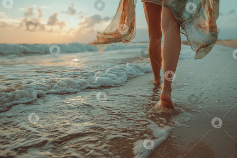 Скачать ноги женщины в парео, идущей по пляжу в полосе прибоя фотосток Ozero