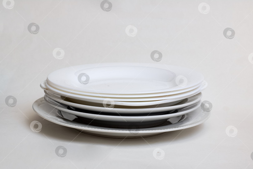 Скачать Стопка старых белых тарелок на сером фоне фотосток Ozero
