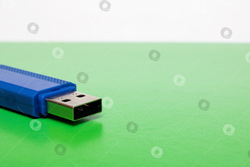 Скачать Синяя usb-флешка на ярко-зеленом фоне фотосток Ozero