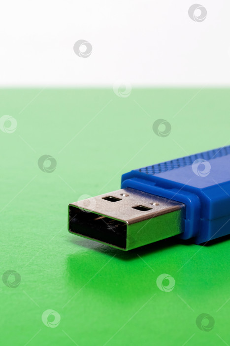 Скачать Синяя usb-флешка на ярко-зеленом фоне фотосток Ozero