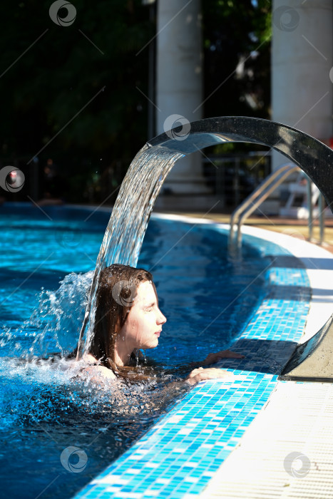 Скачать Молодая женщина, плавающая по воде в бассейне фотосток Ozero