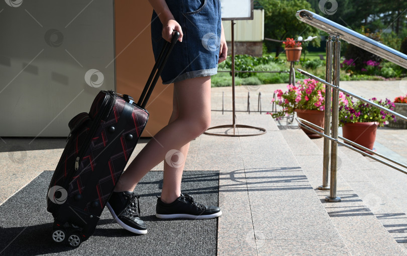 Скачать Элегантная девушка с багажом в вестибюле отеля. Женщина с чемоданом в отпуске или путешествии. фотосток Ozero