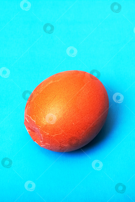 Скачать Коричневое треснувшее яйцо на синем фоне фотосток Ozero